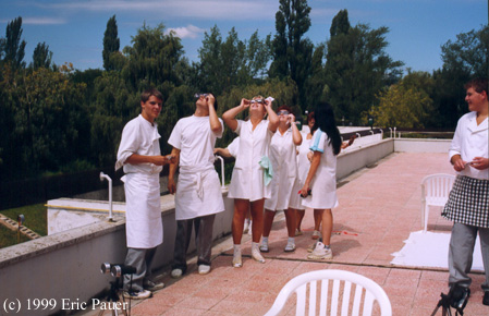 Hotel staff using eclipse viewers to see beginning of eclipse